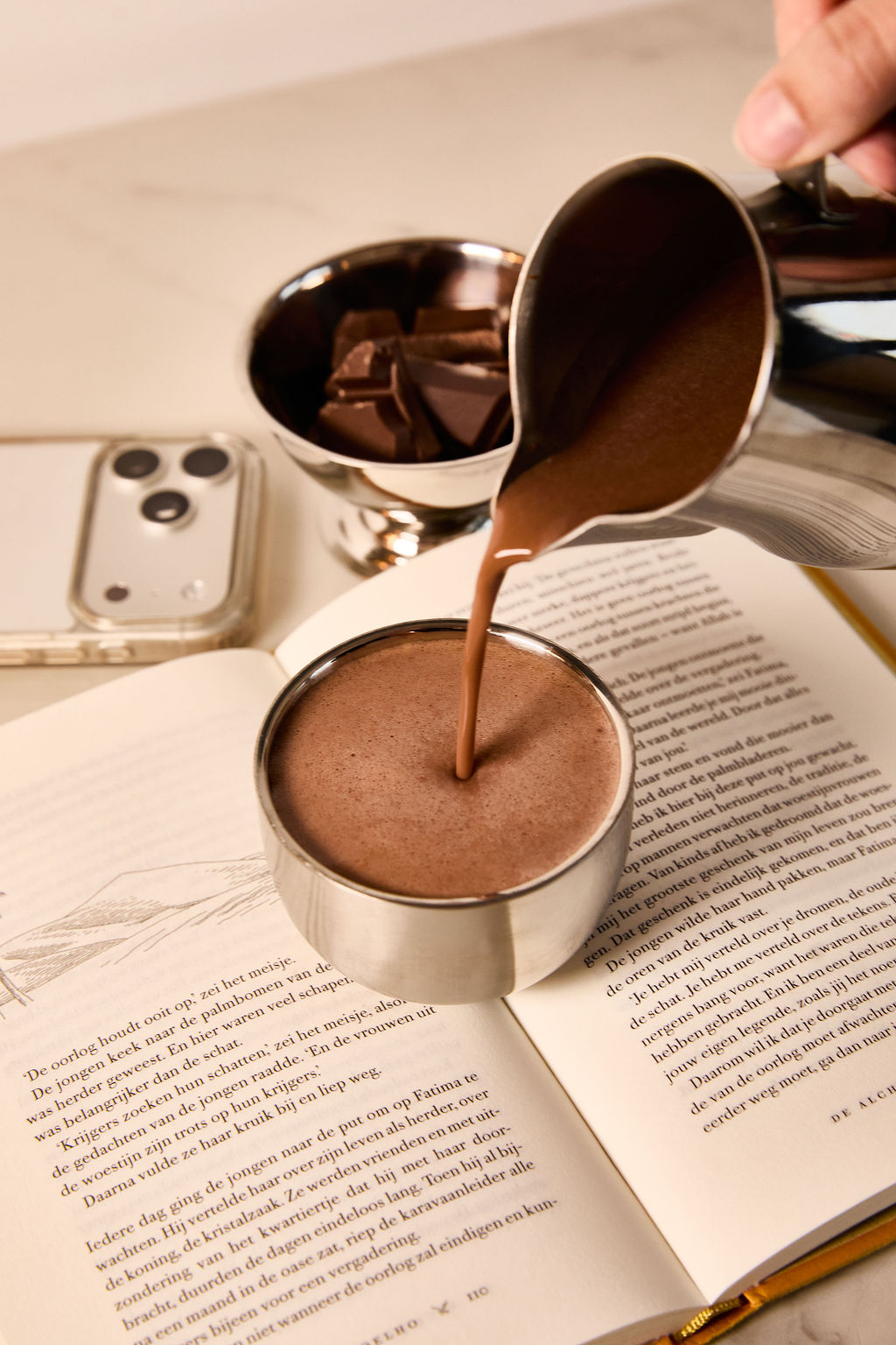 Ceremonial cacao poured into a cup during a calm morning ritual with a book